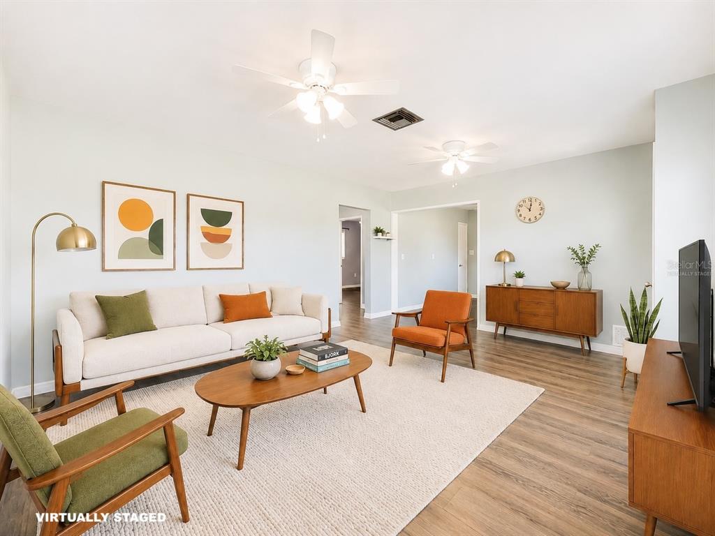 A living room with mid-century modern furniture, a light-colored sofa, and wood-look flooring — 2980 WESTLAND ROAD, MOUNT DORA, FL