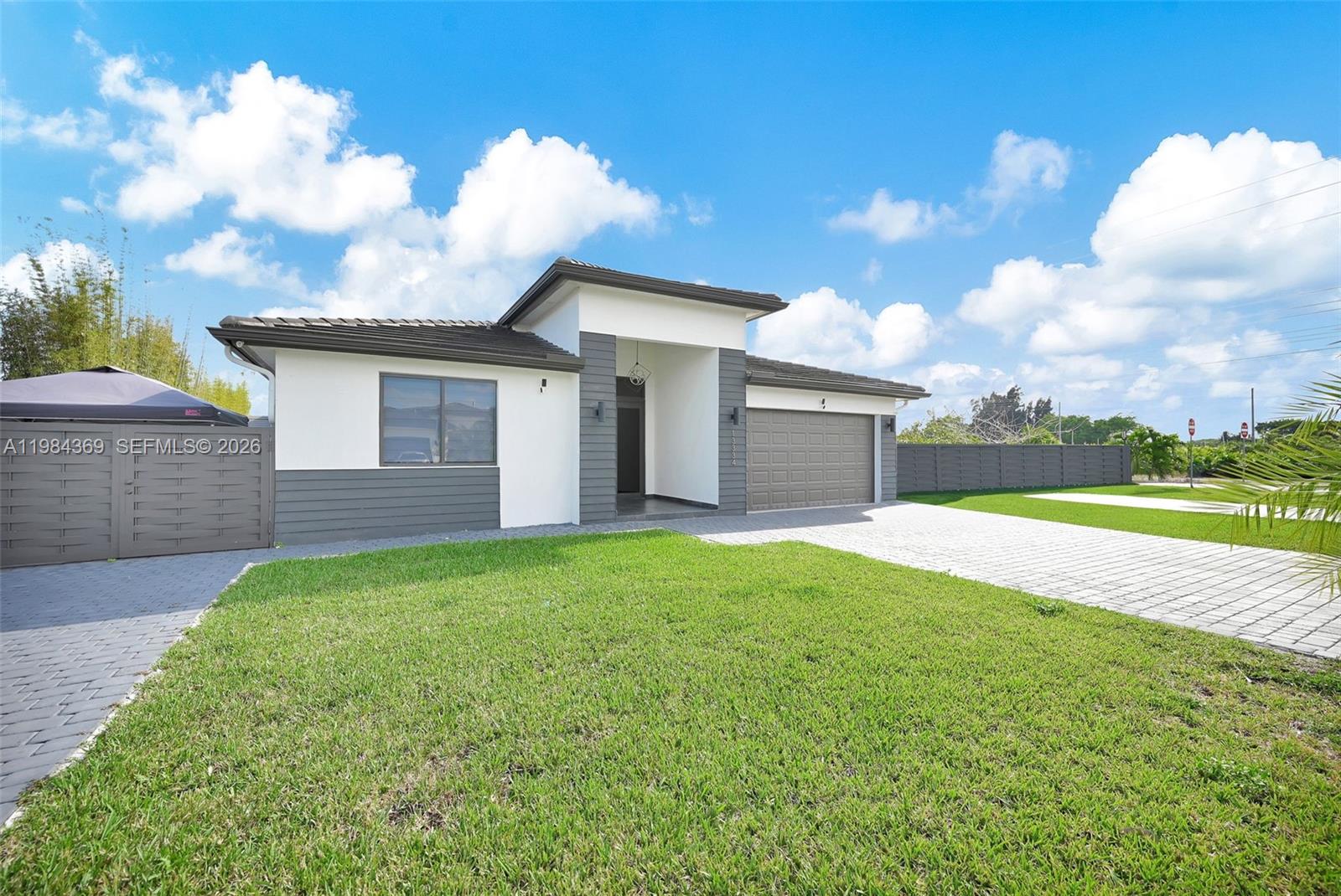 A single-story house with a gray and white exterior, a garage, and a paved driveway — 13334 SW 227th St, Miami FL 33170, MIAMI, FL