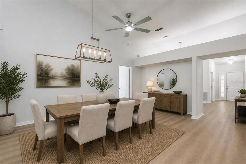 A dining room features a wooden table, upholstered chairs, a chandelier, and light wood flooring — 1804 WESTPOINTE CIRCLE, ORLANDO, FL