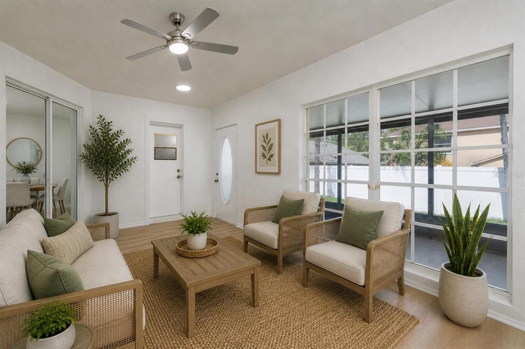 A sunroom features a sofa, two armchairs, a coffee table, and large windows overlooking a yard — 1804 WESTPOINTE CIRCLE, ORLANDO, FL