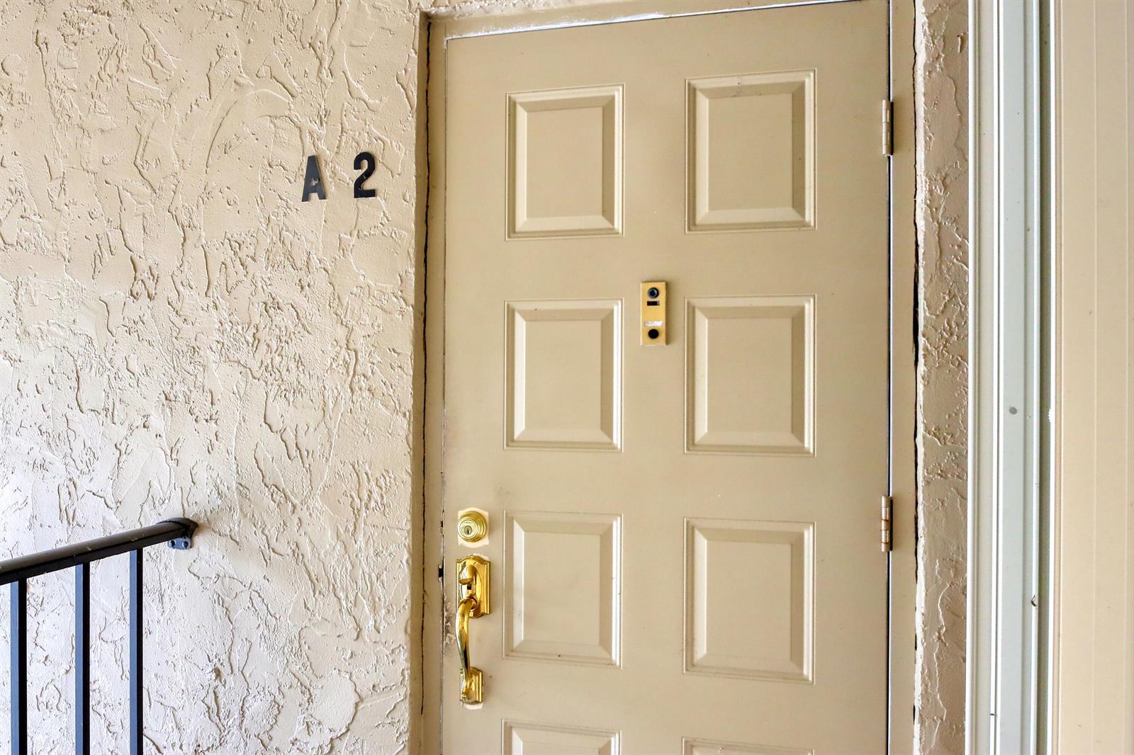 A beige apartment door with a gold handle and the number A 2 on the wall — 715 Sunny Pine Way # A2, FL 33415, FL