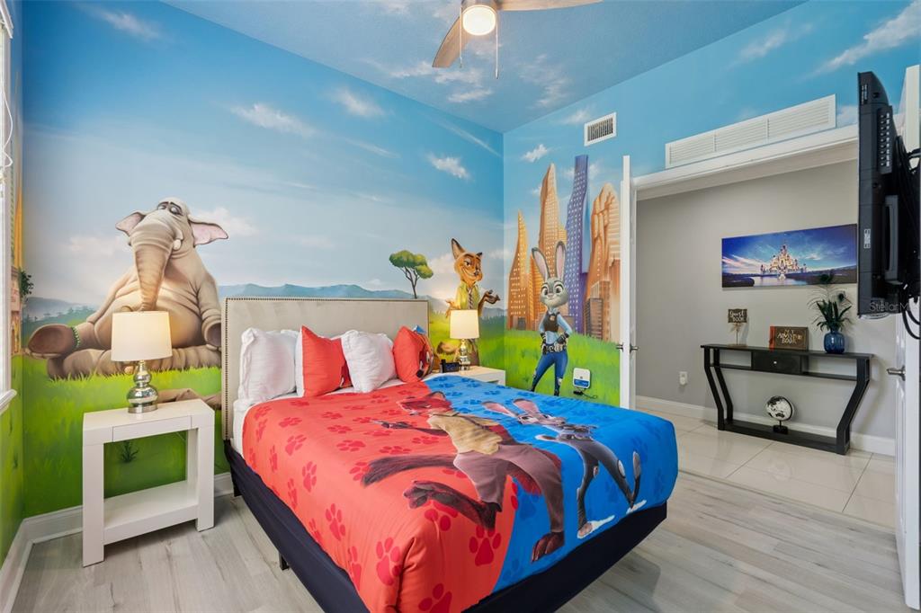A bedroom features Zootopia-themed wall murals, a bed with character bedding, and a mirrored closet — 7468 EXCITEMENT DRIVE UNIT 102, REUNION, FL