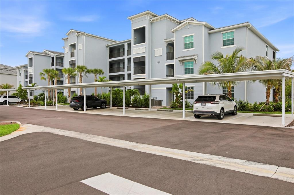 A multi-story apartment building with a covered parking structure in the foreground — 14191 HERITAGE LANDING BOULEVARD UNIT 1216, PUNTA GORDA, FL