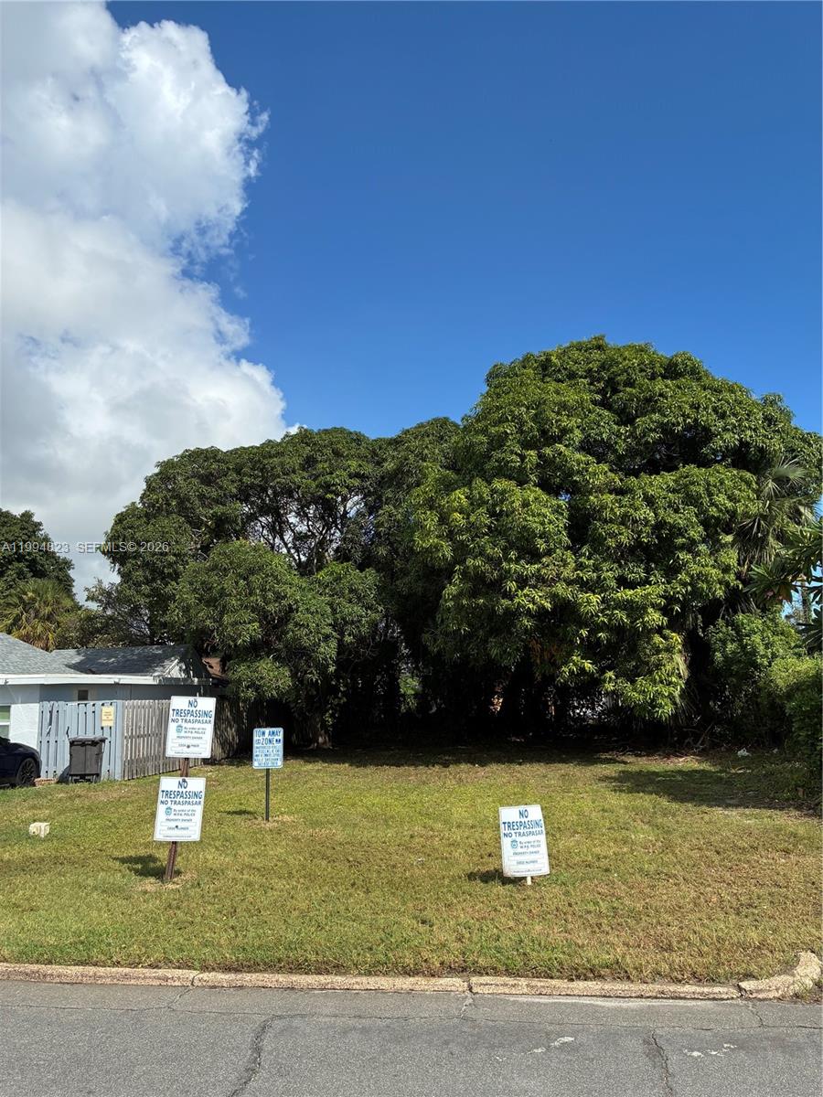 A vacant, grassy lot features several no trespassing signs and large, mature trees — 627 56th St, West Palm Beach FL 33407, WEST PALM BEACH, FL