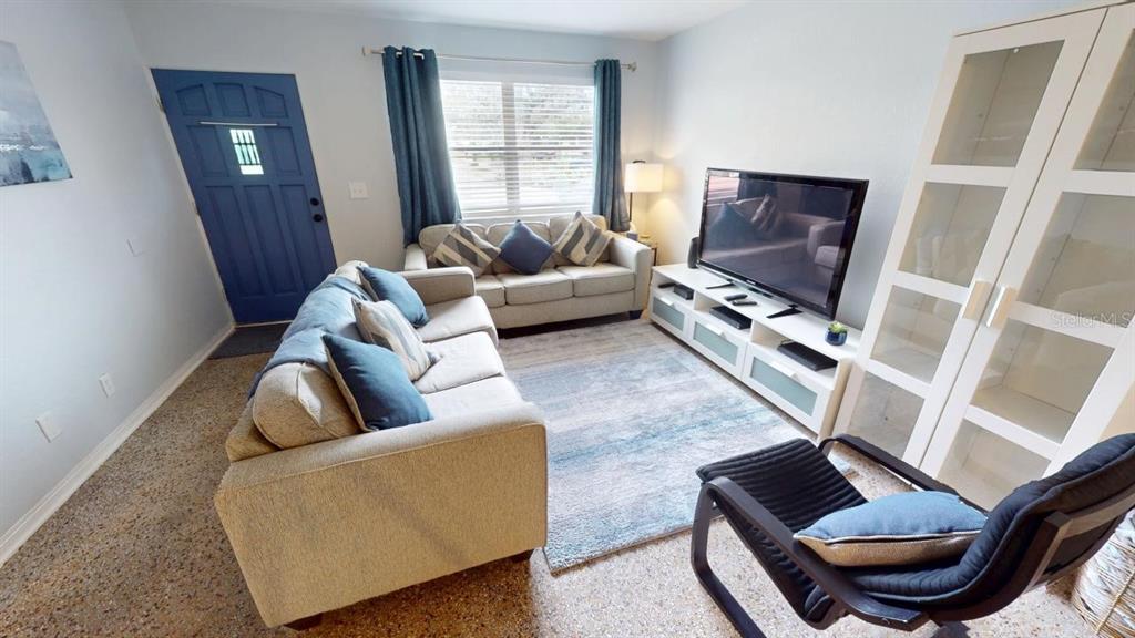 A living room features a blue front door, two beige sofas, and a television console — 328 SLAYTON AVENUE, SOUTH DAYTONA, FL