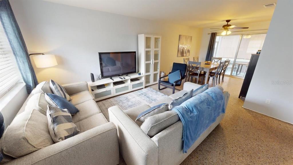 A living room with light-colored sofas, a television console, and an adjacent dining area — 328 SLAYTON AVENUE, SOUTH DAYTONA, FL