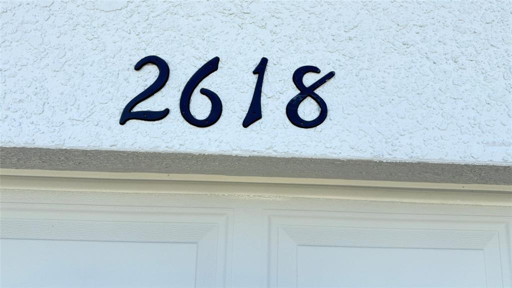 A gray front door and a two-car garage are visible on this house exterior — 2618 IRISH ELK AVENUE, DAVENPORT, FL