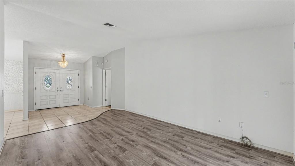 A living room features wood-look flooring, a tiled entryway, and a double front door — 549 PENINSULAR DRIVE, LAKELAND, FL