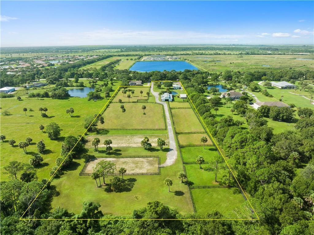 An aerial view shows a fenced rural property with multiple pastures, outbuildings, and a driveway — 8530 8th Street, Vero Beach FL 32968, VERO BEACH, FL