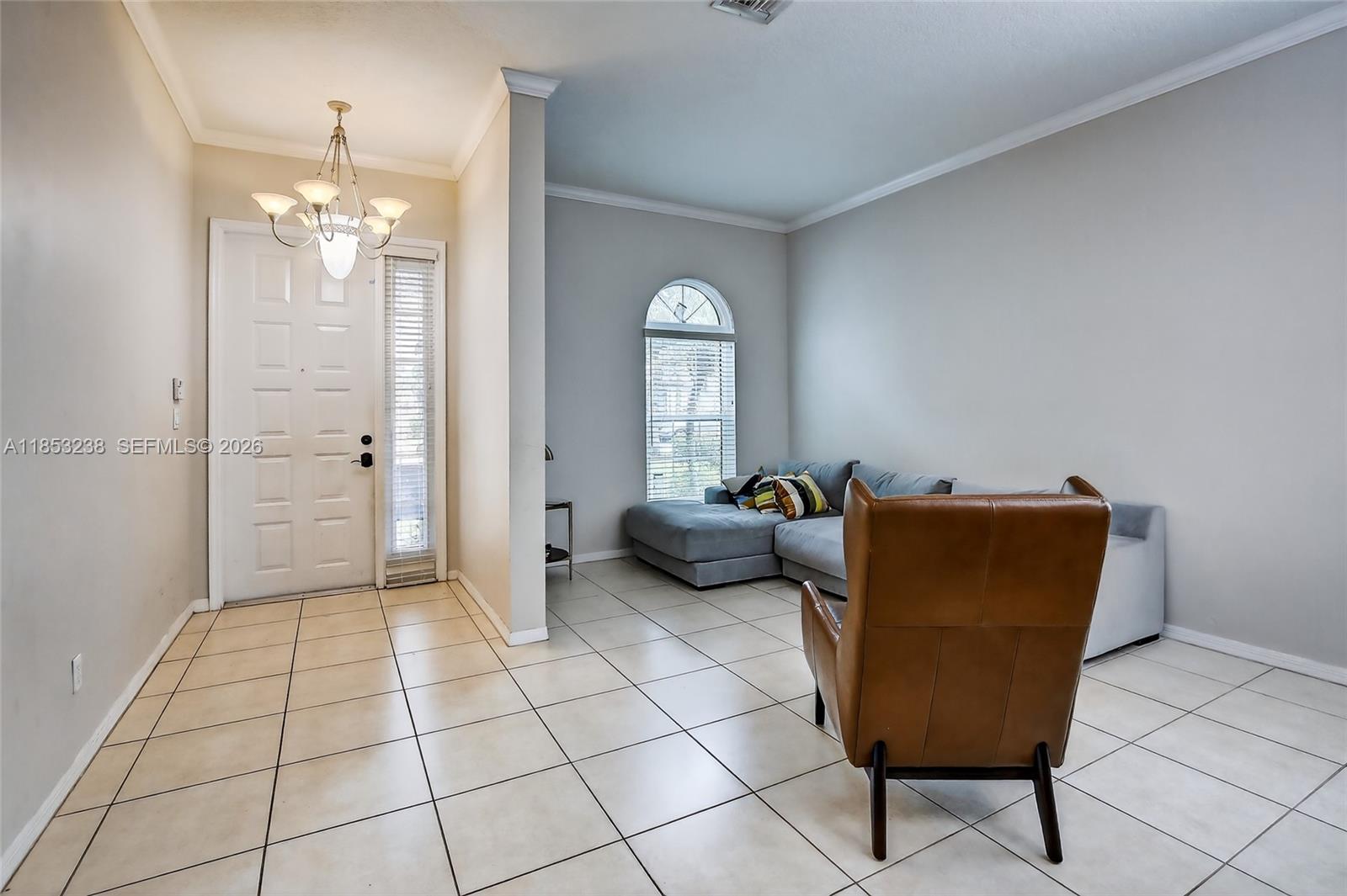 A living room features light tile flooring, a grey sectional sofa, and a brown leather chair — 19138 Stonebrook St, Weston FL 33332, WESTON, FL