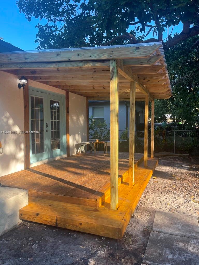 A wooden deck with a covered porch sits outside a house with light blue doors — 5529 NW 4th Ave # 2, Miami FL 33127, MIAMI, FL