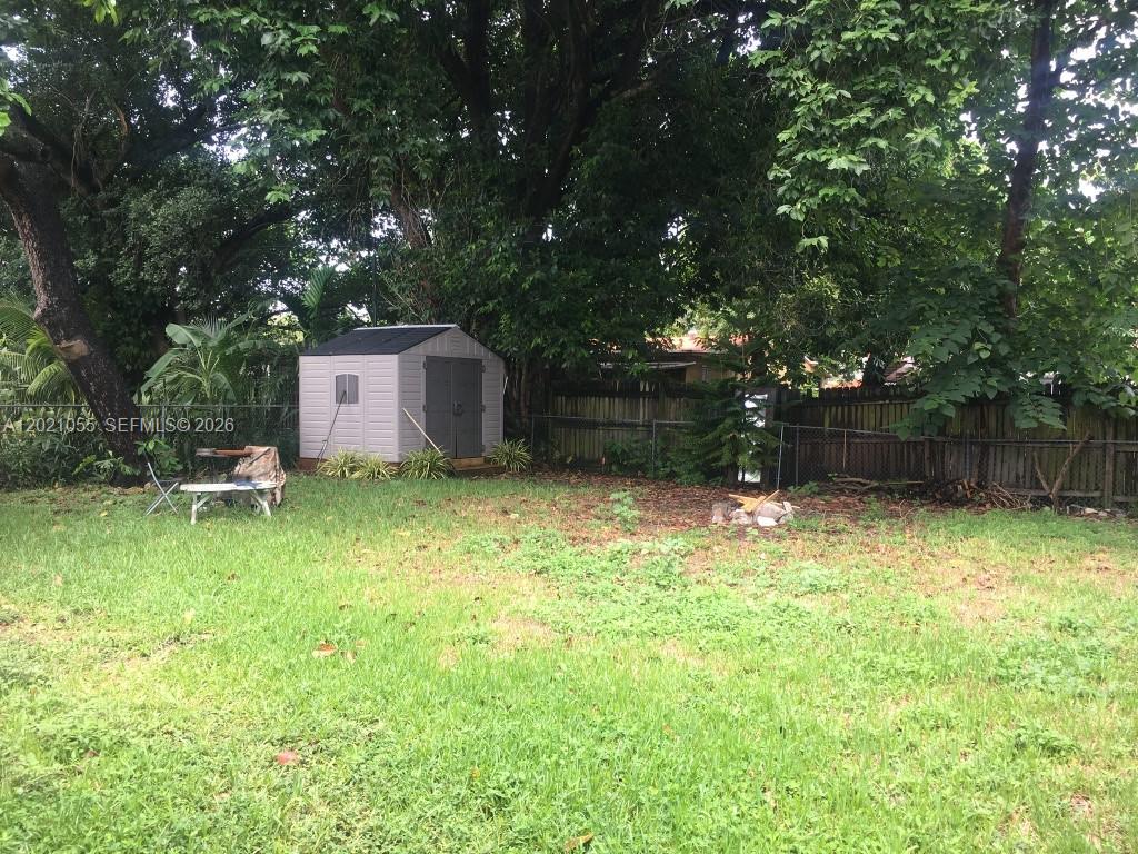A backyard features a small storage shed, a folding table, and a wooden fence — 5529 NW 4th Ave # 2, Miami FL 33127, MIAMI, FL
