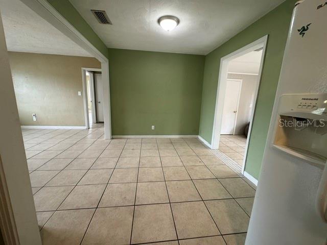 A dining area with beige tile flooring and green walls leads to two adjacent rooms — 2976 POPLAR STREET, SARASOTA, FL