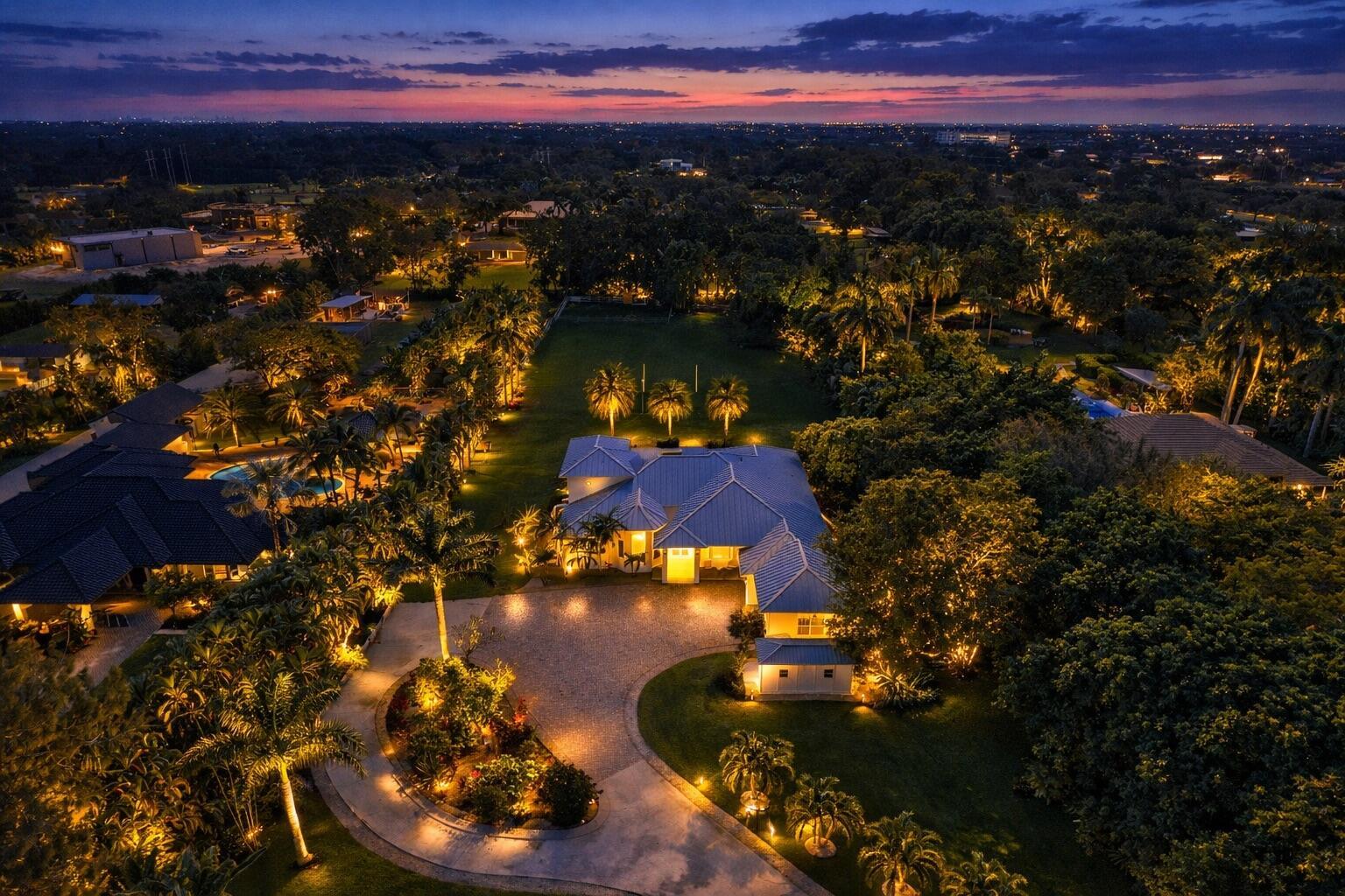 An aerial view of a lit house with a circular driveway and a large backyard — 14600 Sunset Lane, Southwest Ranches FL 33330, SOUTHWEST RANCHES, FL
