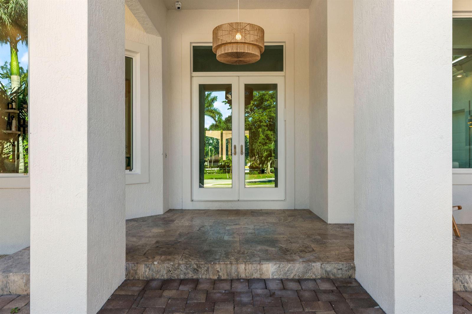 A covered entryway features stone steps, a woven pendant light, and double glass doors — 14600 Sunset Lane, Southwest Ranches FL 33330, SOUTHWEST RANCHES, FL