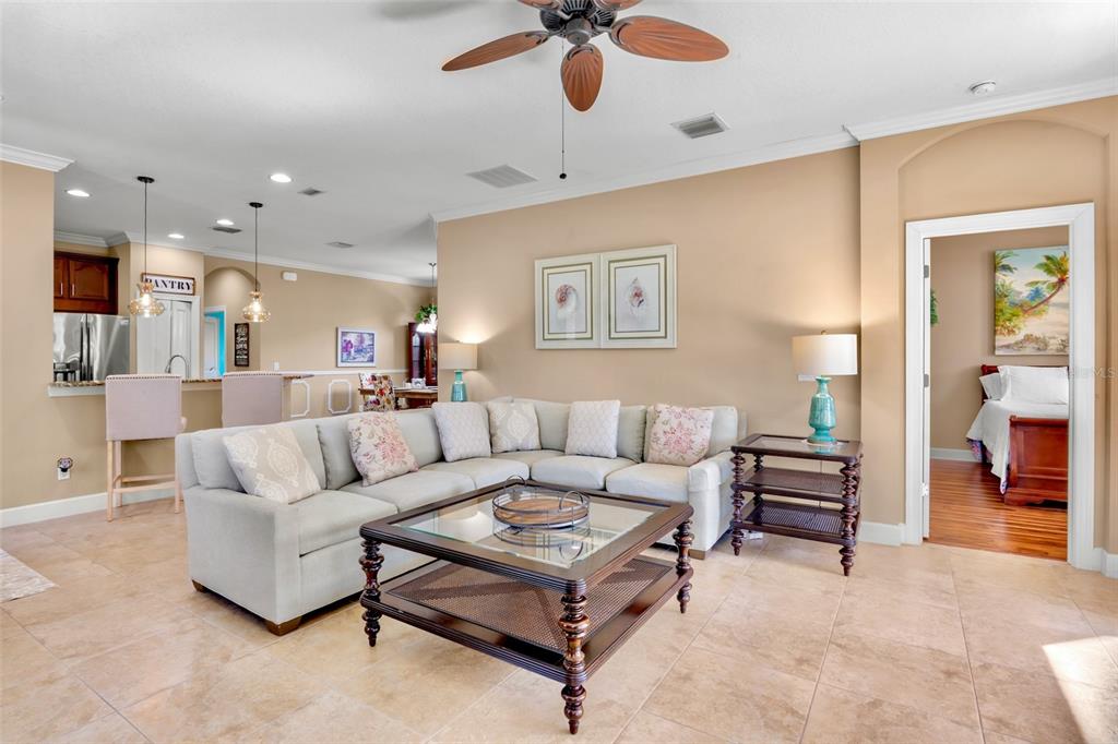 A living room features a large sectional sofa, a coffee table, and a ceiling fan — 13218 TORRESINA TERRACE, BRADENTON, FL