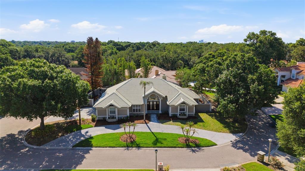 An aerial view of a single-story house with a light-colored roof and a circular driveway — 8935 JONATHAN MANOR DRIVE, ORLANDO, FL