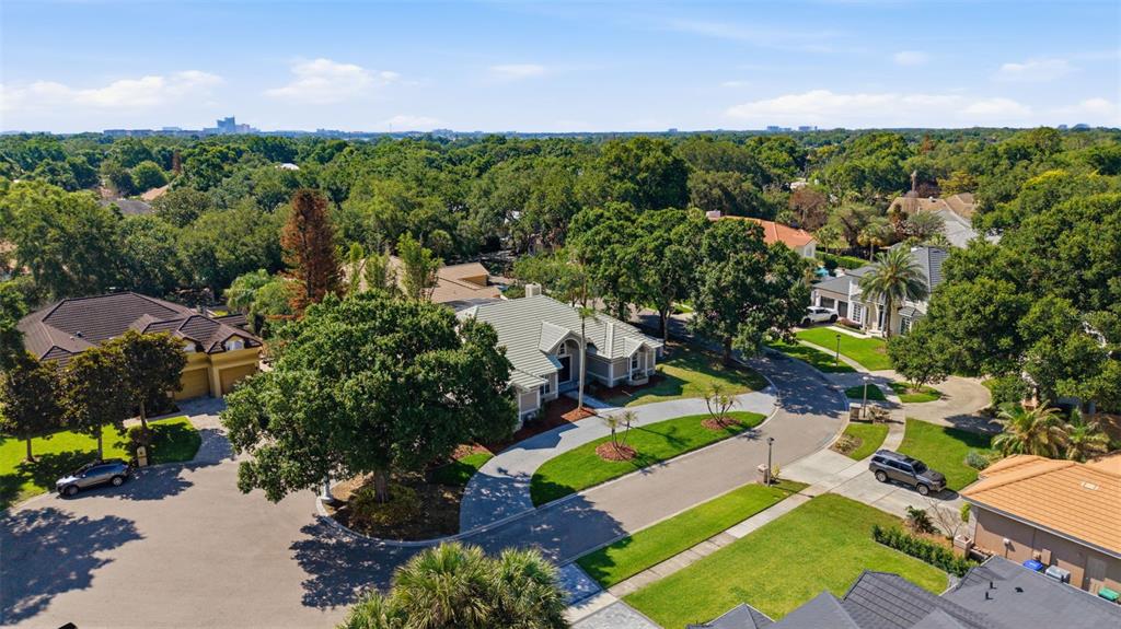 An aerial view shows a suburban neighborhood with houses, paved streets, and mature trees — 8935 JONATHAN MANOR DRIVE, ORLANDO, FL