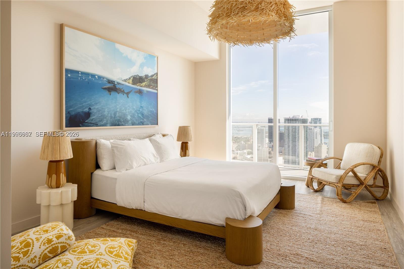 A modern bedroom features a platform bed, a large ocean artwork, and floor-to-ceiling city views — 275 SW 6th St # 1110, Miami FL 33130, MIAMI, FL