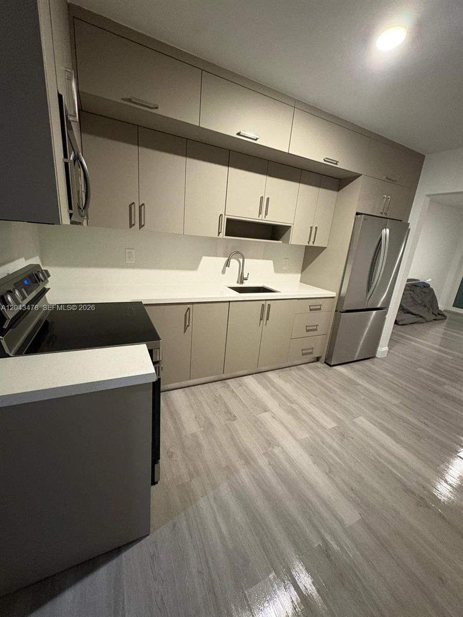 A modern kitchen features light-toned cabinetry, stainless steel appliances, and white countertops — 225 SW 76th Ct # 227, Miami FL 33144, MIAMI, FL