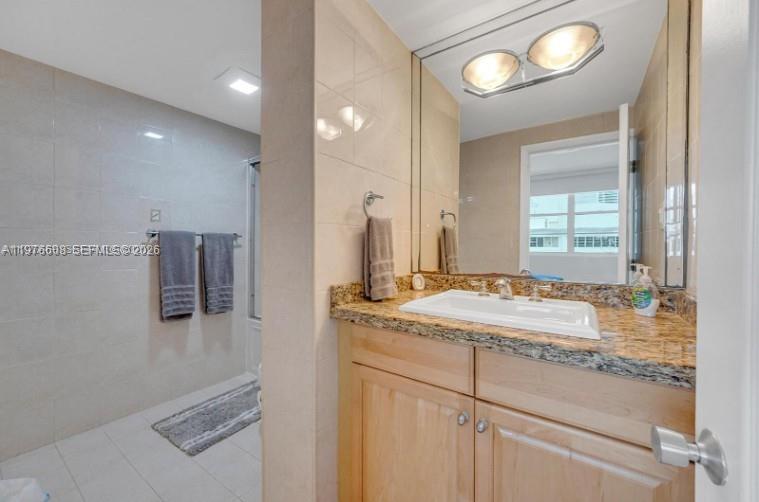 A bathroom features a light wood vanity, a white sink, and a walk-in shower — 999 Brickell Bay Dr # 2007, Miami FL 33131, MIAMI, FL