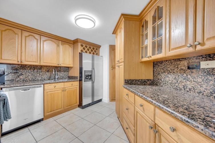 A kitchen features light wood cabinets, granite countertops, a stainless steel refrigerator, and tile flooring — 999 Brickell Bay Dr # 2007, Miami FL 33131, MIAMI, FL