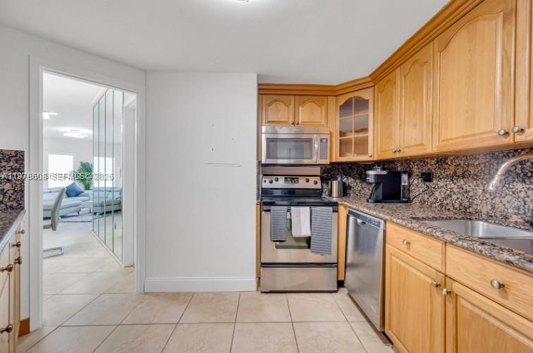 A kitchen features light wood cabinets, stainless steel appliances, and a tiled floor — 999 Brickell Bay Dr # 2007, Miami FL 33131, MIAMI, FL