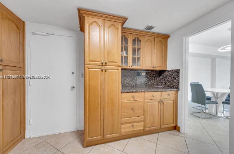 A kitchen area features light wood cabinetry, granite countertops, and a tiled floor — 999 Brickell Bay Dr # 2007, Miami FL 33131, MIAMI, FL