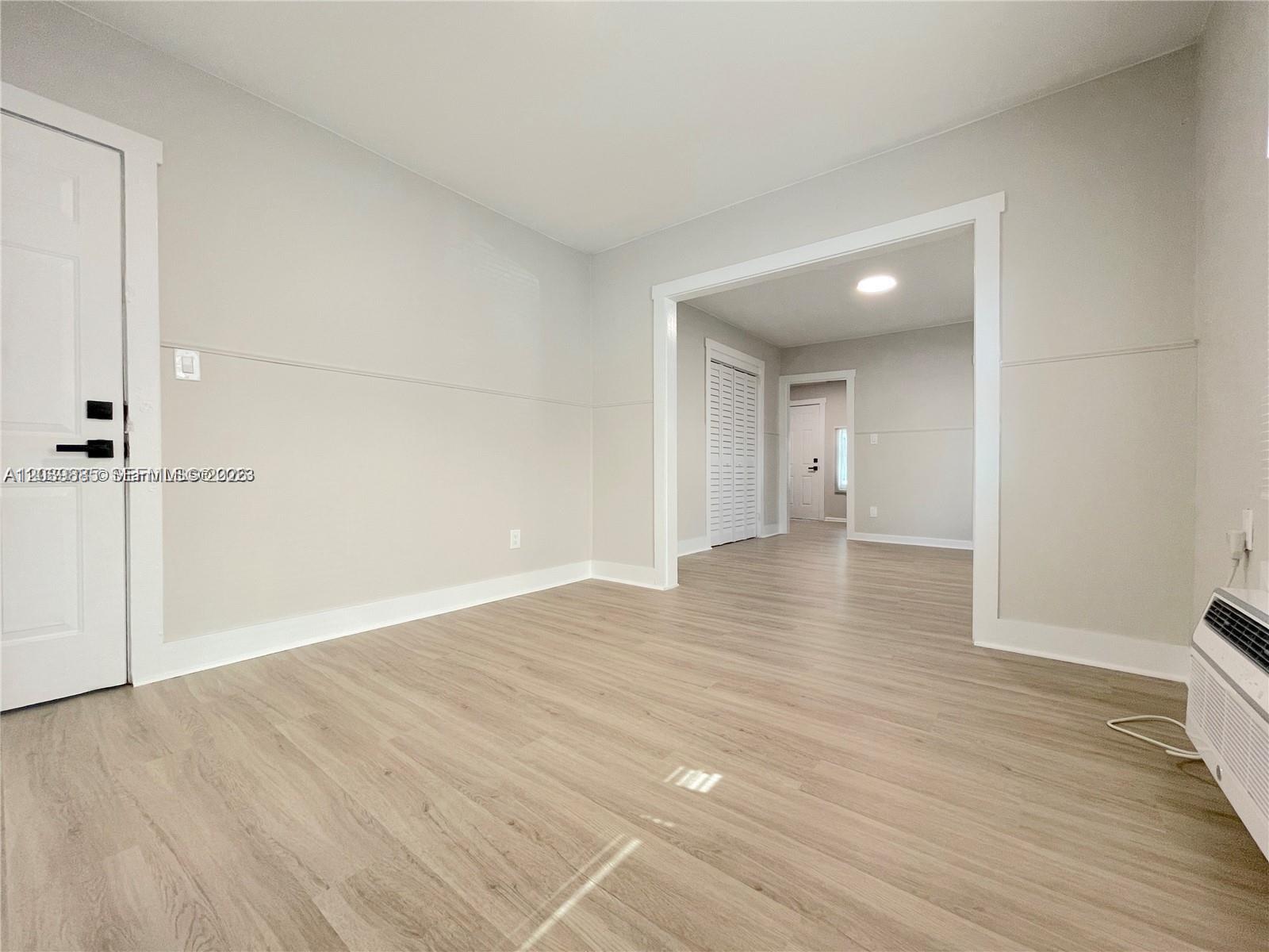 An interior view showing a room with light wood-look flooring and a wide doorway — 1836 Dewey St # 2, Hollywood FL 33020, HOLLYWOOD, FL