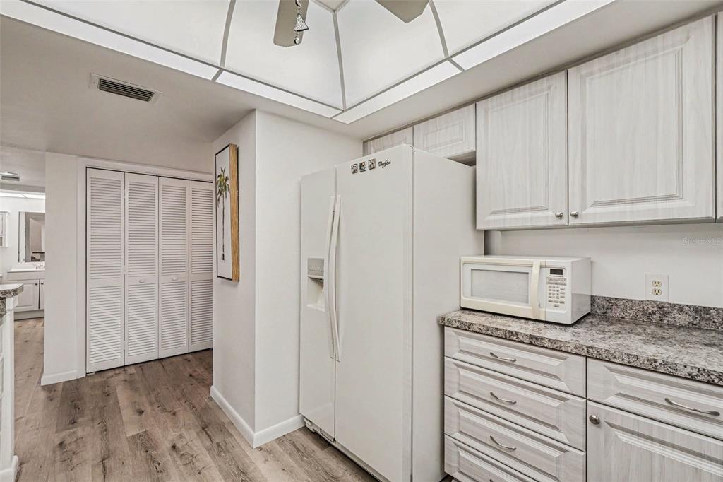 A kitchen features light wood-grain cabinets, a white refrigerator, and a granite countertop — 601 SHREVE STREET UNIT 66A, PUNTA GORDA, FL