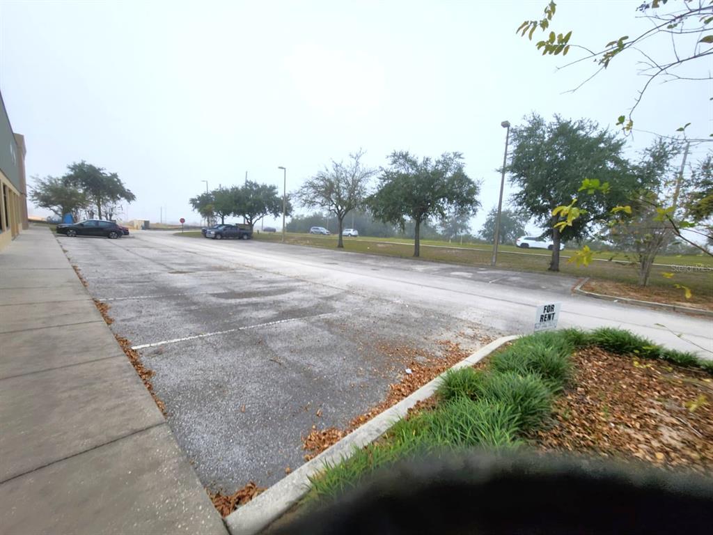 A paved parking lot sits in front of a building with trees in the background — 2135 S 30TH STREET, HAINES CITY, FL