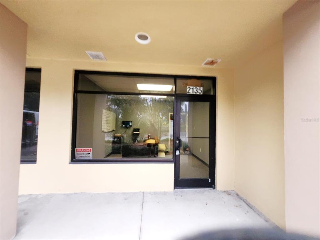 The exterior entrance of a commercial unit features a glass door and large display window — 2135 S 30TH STREET, HAINES CITY, FL