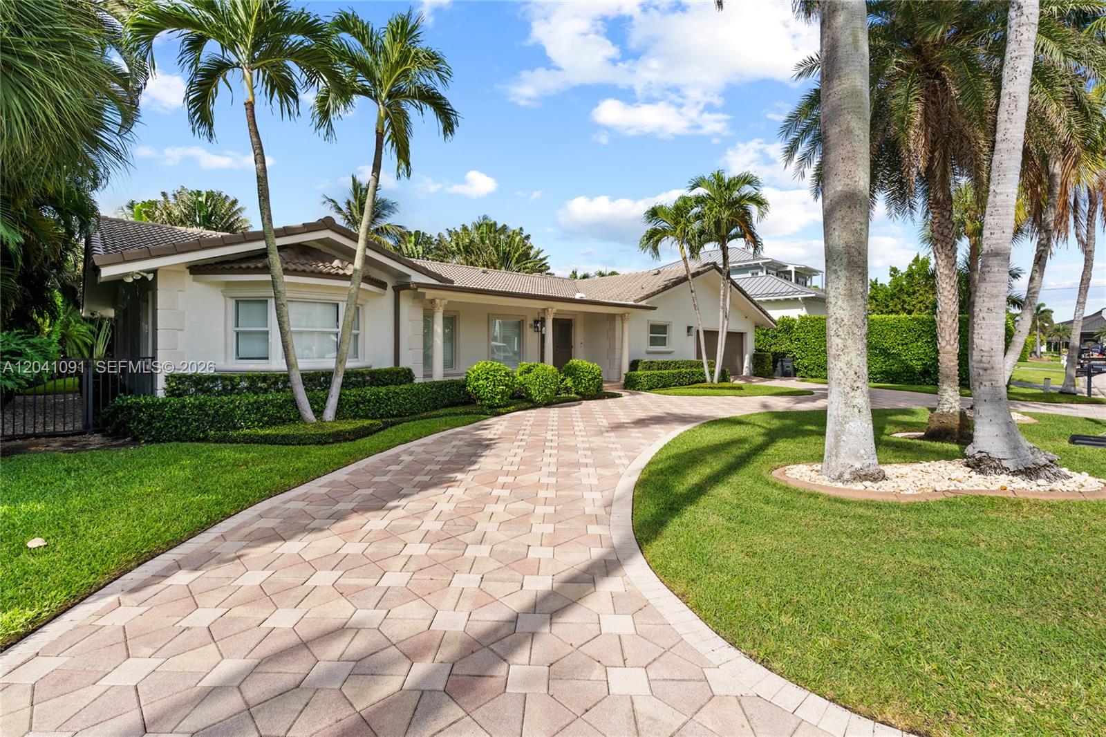 A single-story house with a paved driveway, palm trees, and manicured landscaping — 18 Eleuthera Dr, Ocean Ridge FL 33435, OCEAN RIDGE, FL