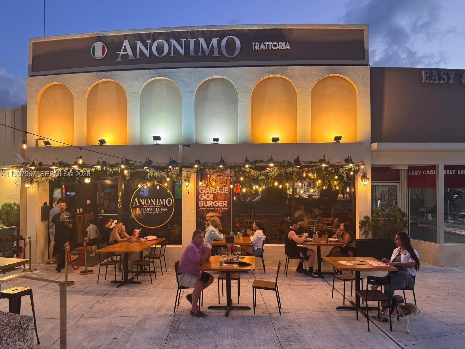An outdoor dining area with tables and chairs sits in front of a restaurant building — 946 Normandy Dr, Miami Beach FL 33141, MIAMI BEACH, FL