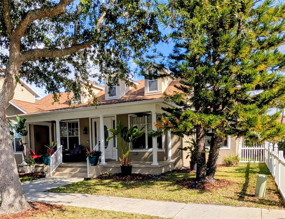 A tan house with a front porch, dormer windows, and mature trees in the yard — 3618 BUFFETT STREET, NEW PORT RICHEY, FL