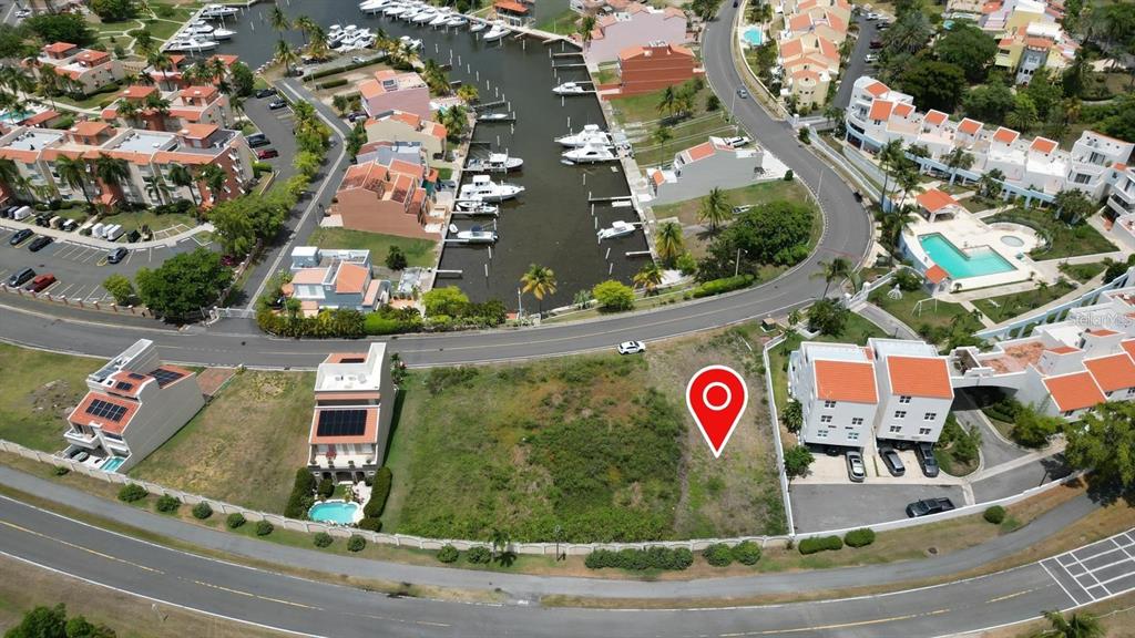 An aerial view shows a vacant lot situated between residential buildings and a marina — HARBOUR DRIVE DR. #13 E PALMAS DEL MAR, HUMACAO, PR