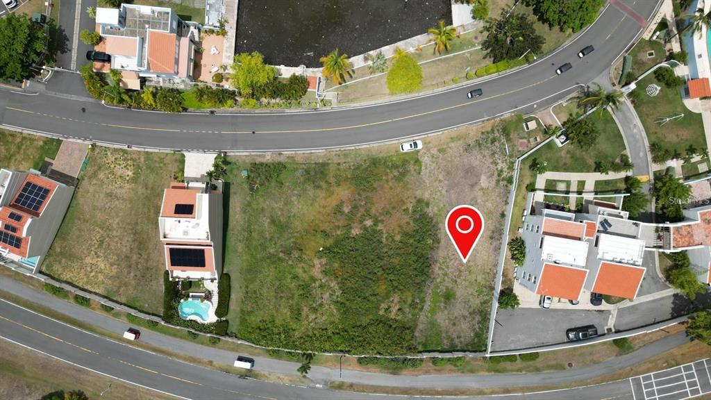 An aerial view shows a vacant lot situated between two residential buildings near a curved road — HARBOUR DRIVE DR. #13 E PALMAS DEL MAR, HUMACAO, PR
