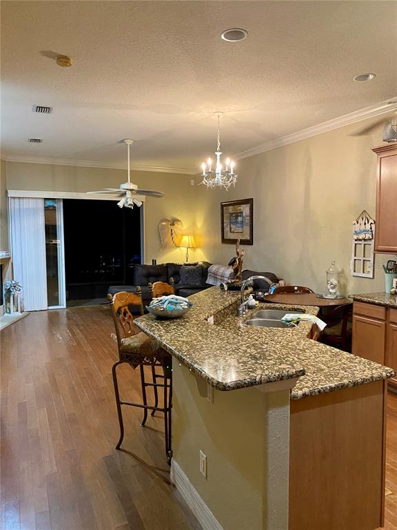 A kitchen with granite countertops and a breakfast bar overlooks a living room area — 1051 GREEN GATE BOULEVARD, GROVELAND, FL