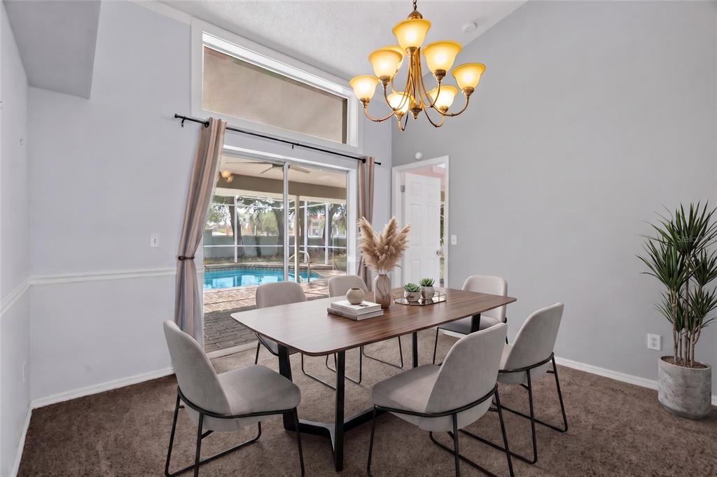 A dining room with a wooden table, six chairs, a chandelier, and a sliding glass door — 1174 MUSCOVY DRIVE, SPRING HILL, FL