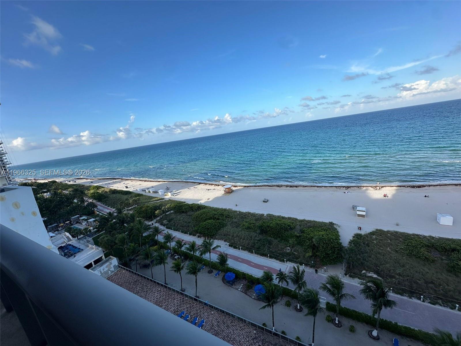 A high-angle view of a sandy beach and ocean from a balcony — 6039 Collins Ave # 1517, Miami Beach FL 33140, MIAMI BEACH, FL