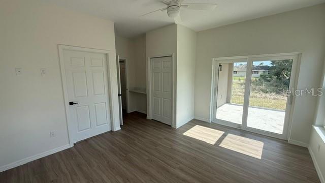 A room with light wood-look flooring, white walls, two interior doors, and sliding glass doors — 4123 MANDARIN ROAD, SEBRING, FL