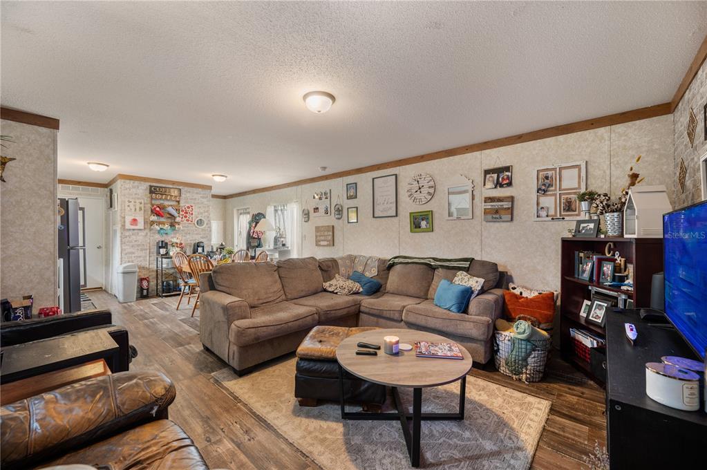 A living room with a sectional sofa, coffee table, and adjacent dining area — 4770 SUGARFOOT AVENUE, LAKE WALES, FL