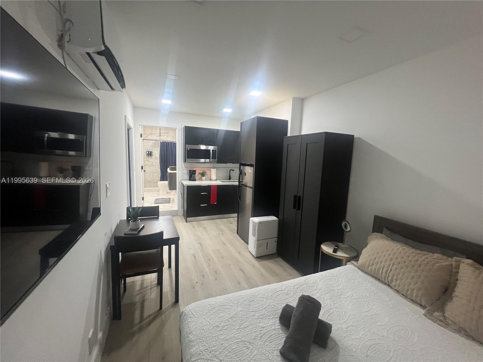 A studio apartment features a kitchenette, a bed, a dining table, and a bathroom entrance — 2723 SW 13th St, Miami FL 33145, MIAMI, FL