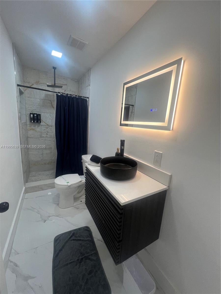 A modern bathroom features a floating vanity, vessel sink, LED mirror, and a tiled shower — 2723 SW 13th St, Miami FL 33145, MIAMI, FL