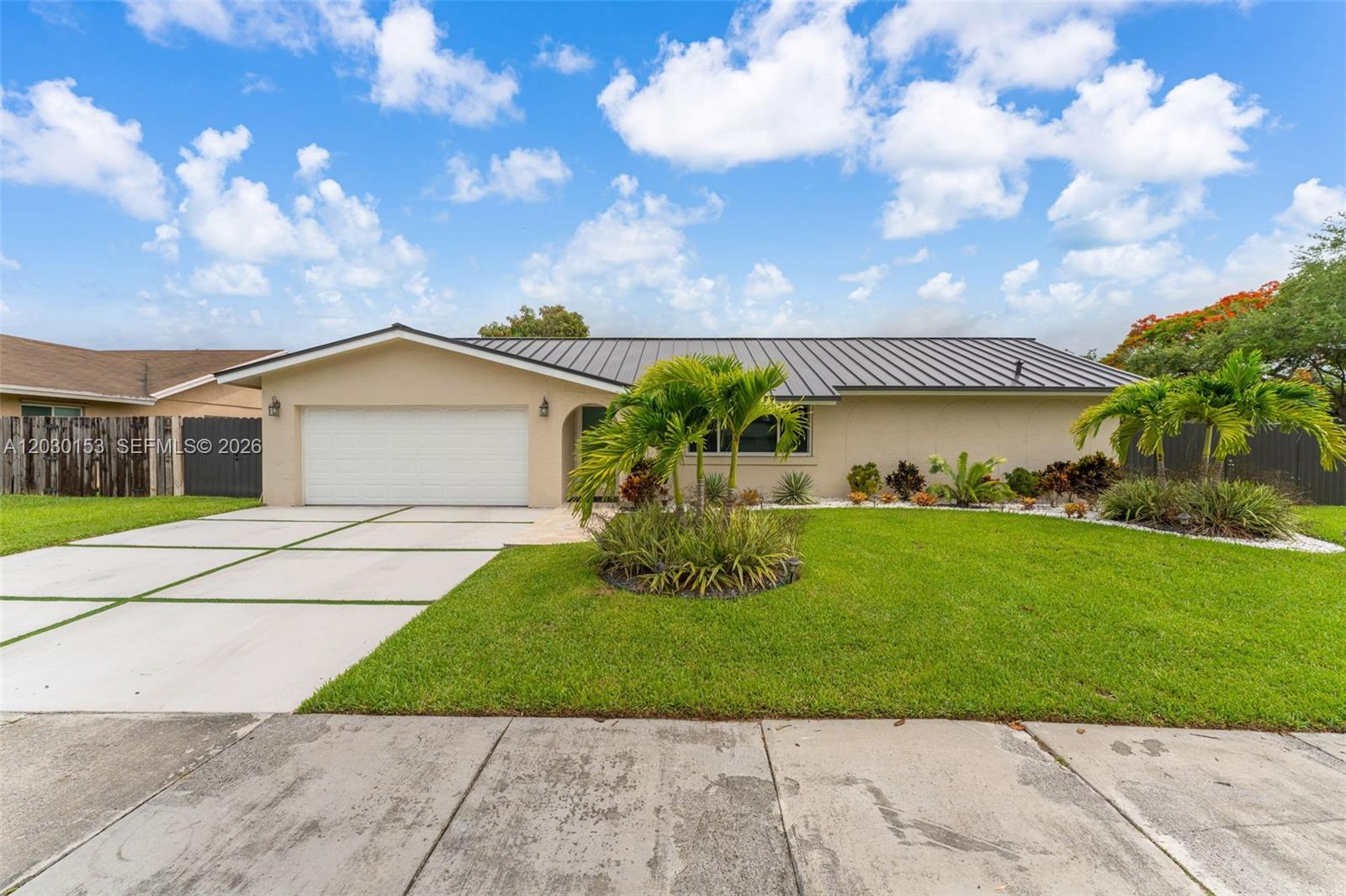 A single-story house with a metal roof, a white garage door, and a paved driveway — 11375 SW 113th Ter, Miami FL 33176, MIAMI, FL