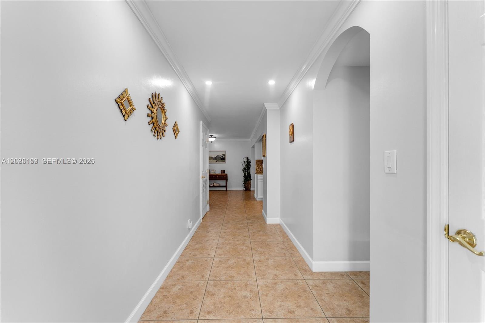 A long hallway with white walls, crown molding, and light-colored tile flooring — 11375 SW 113th Ter, Miami FL 33176, MIAMI, FL