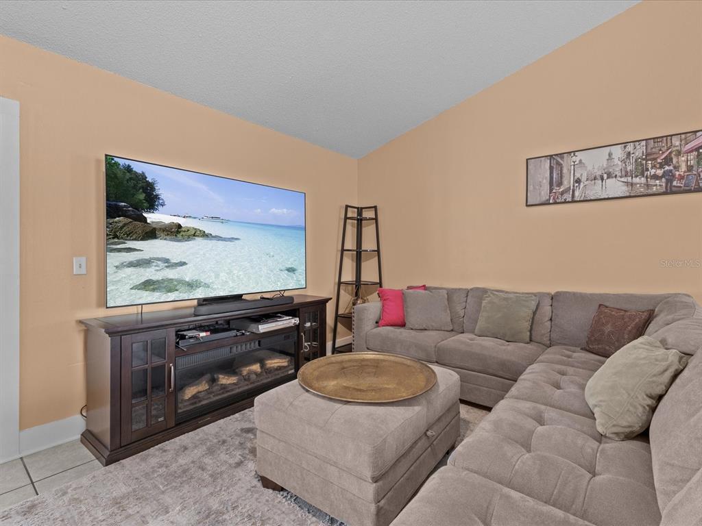 A living room features a large television, a fireplace console, and a sectional sofa — 226 WINDWARD WAY, DAVENPORT, FL