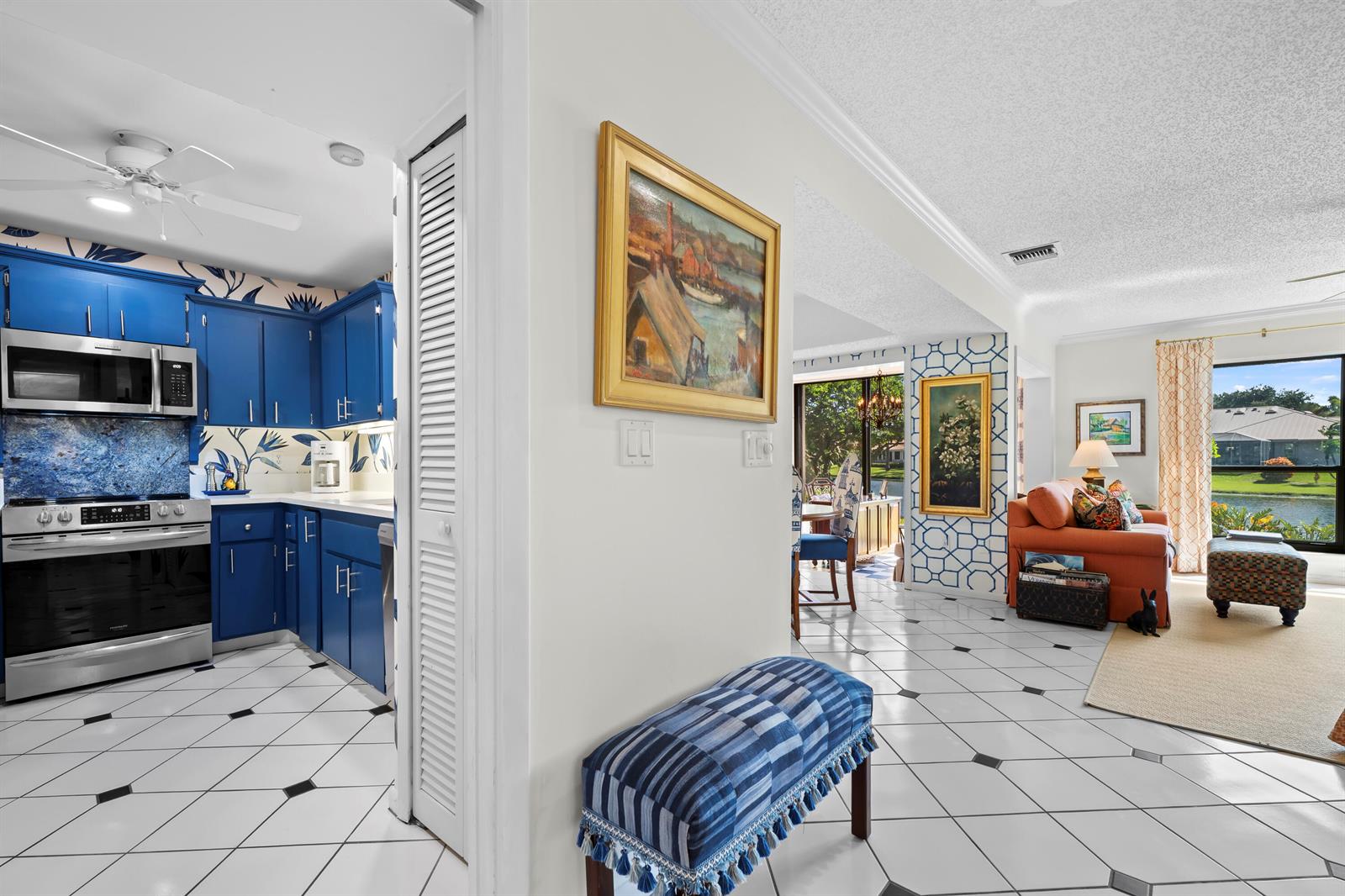 A kitchen with blue cabinets and a living area with tile floors and water views — 5610 SE Foxcross Place, Stuart FL 34997, STUART, FL