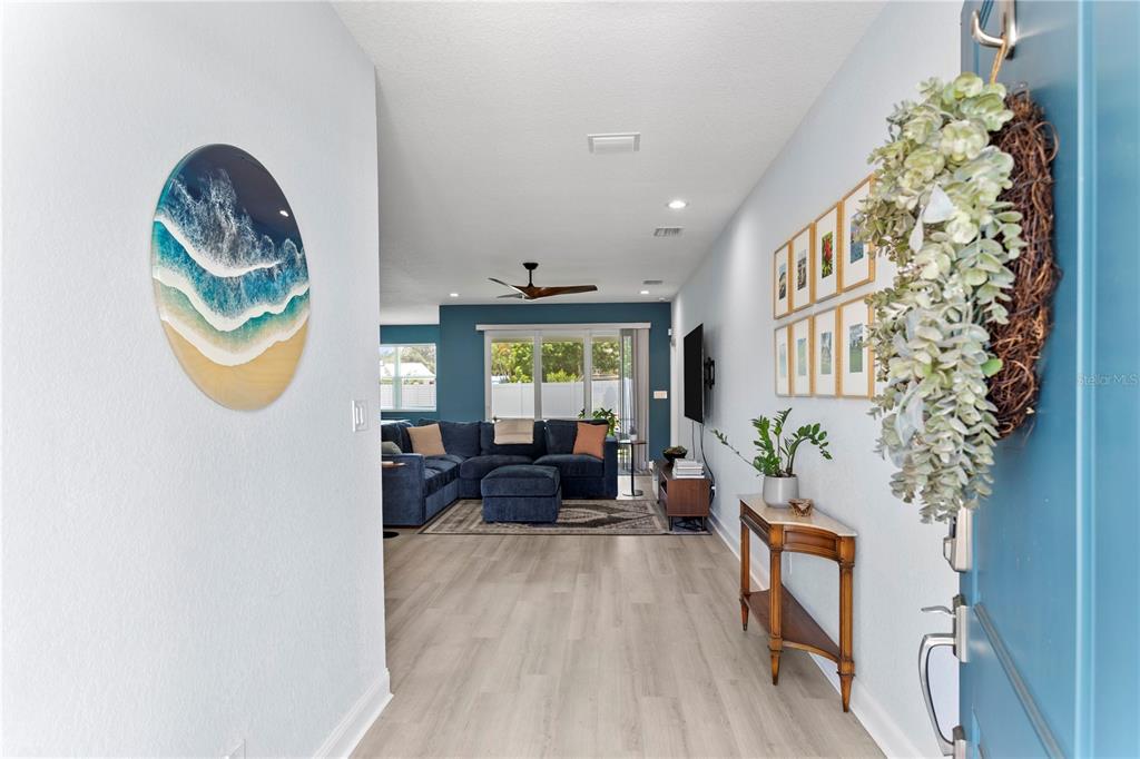 A view from an entryway into a living room with light flooring and blue walls — 5220 94TH AVENUE N, PINELLAS PARK, FL