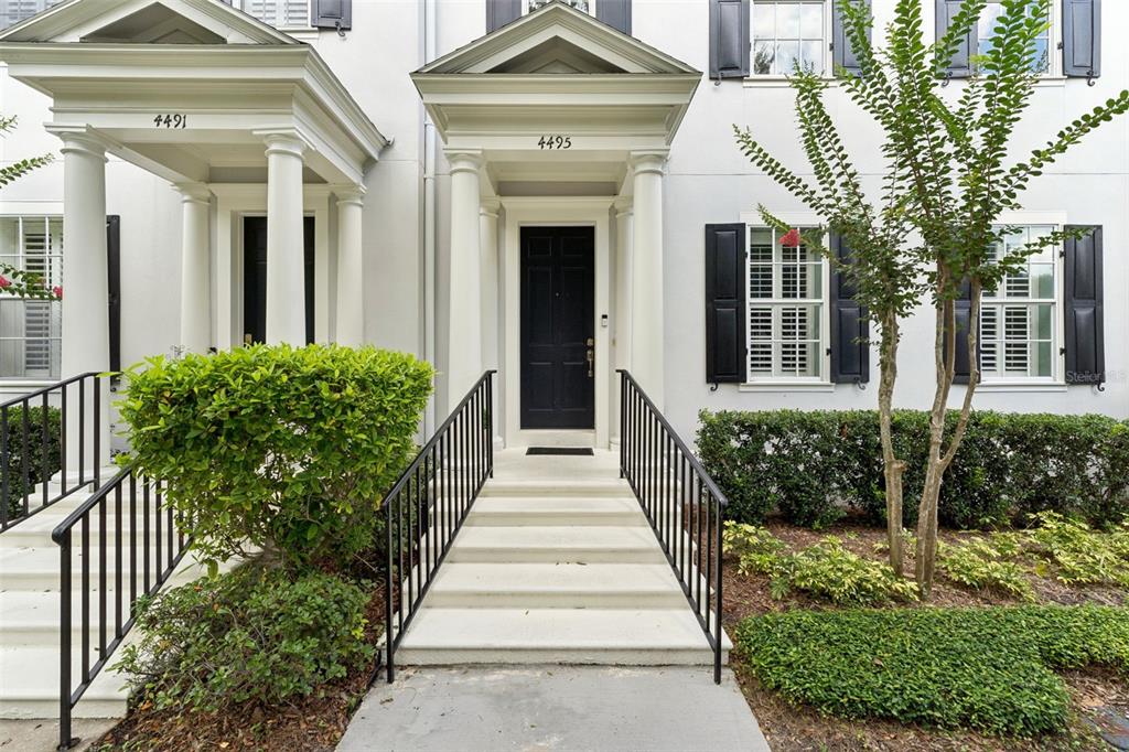 The exterior of a white building features two symmetrical entrances with black doors and railings — 4495 TWINVIEW LANE, ORLANDO, FL